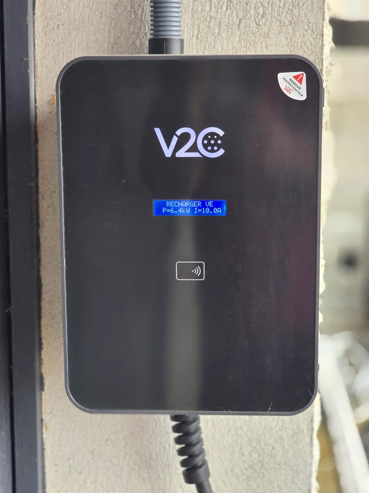 Wallbox V2C posée au mur, écran de charge allumé — chantier Solaurea